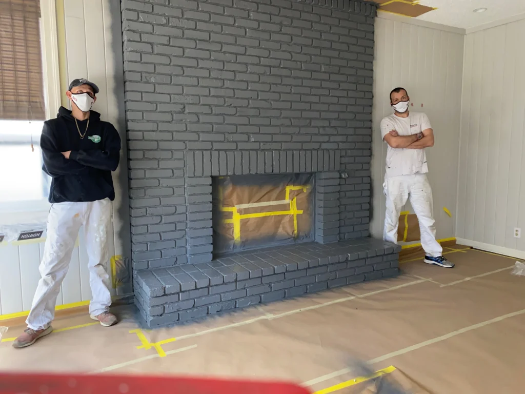 Calgary painting contractors by freshly painted fireplace.