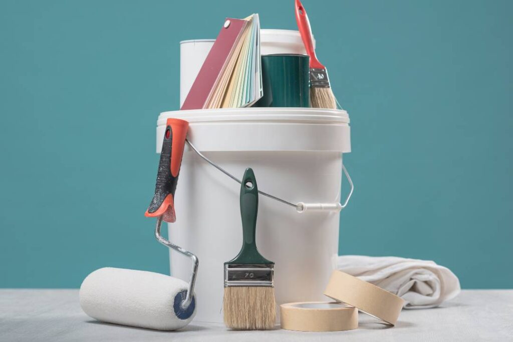 Painting tools for professional painters – brushes, roller, and paint samples ready for use.